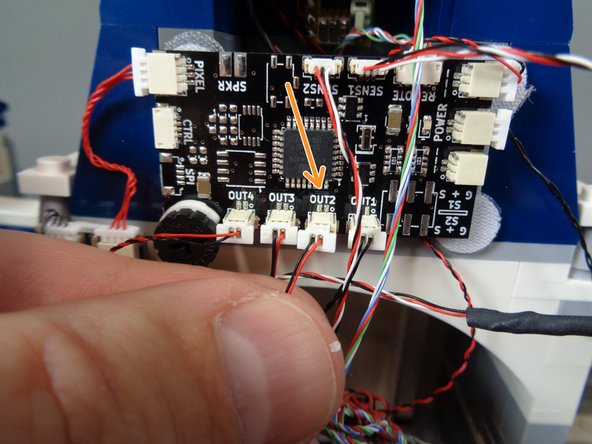 As shown by the orange arrow in the second photo, connect the chandelier light wire to the OUT2 connector on the TRUNK08 master controller.