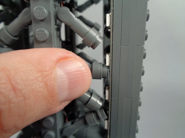 As shown in the photos for this step, attach the top of strip #1 to the tower frame, and re-position brace elements as needed to make room for the LED lights and strip.