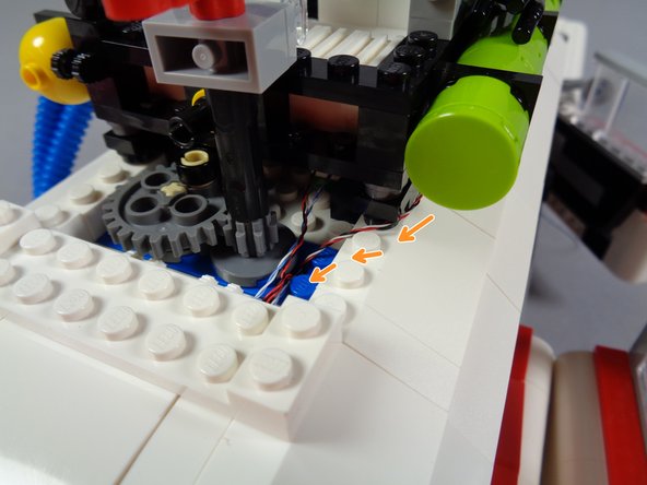 The orange arrows in the second photo show the lightbar wire running along the edge of the roof supports, then down through the hole.