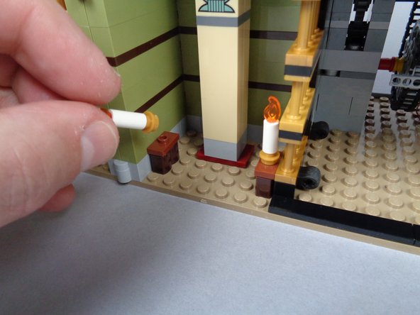 As shown in the photos for this step, remove the two candles from the obelisk room, and separate the candles from their gold plate bases.