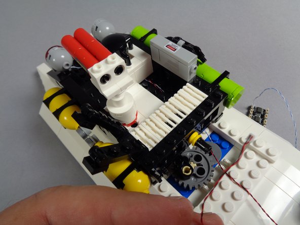 As shown in the second photo for this step, pull the light wire out from under the bottom of the roof plate.