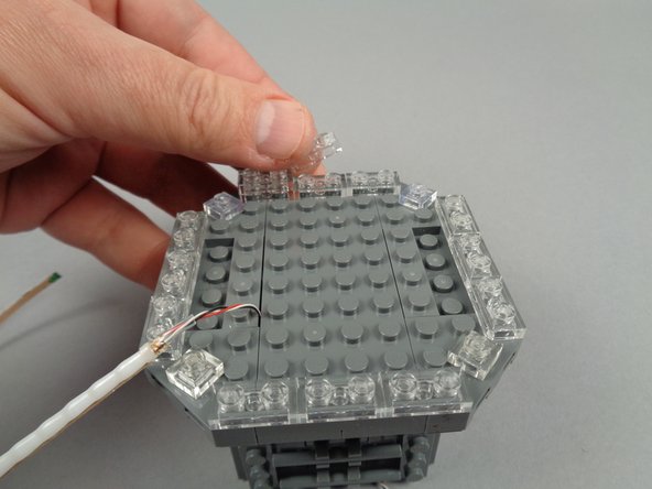 As shown in the photos for this step, use the clear LEGO plates inside the parts bag to extend the clear section of the broadcast tower by one plate height.
