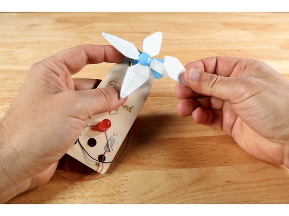 Stick each of the fan blades to the tape pieces as shown with the guidelines facing outward.
