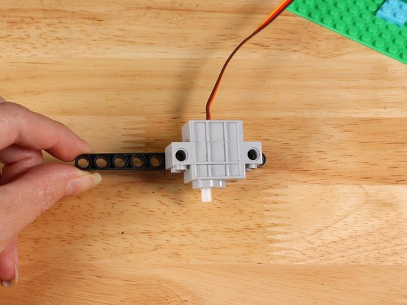 Connect the servo to a LEGO technic beam with the wires at the bottom. In this guide we used an 11-hole long beam. You can also use a different size and modify accordingly.