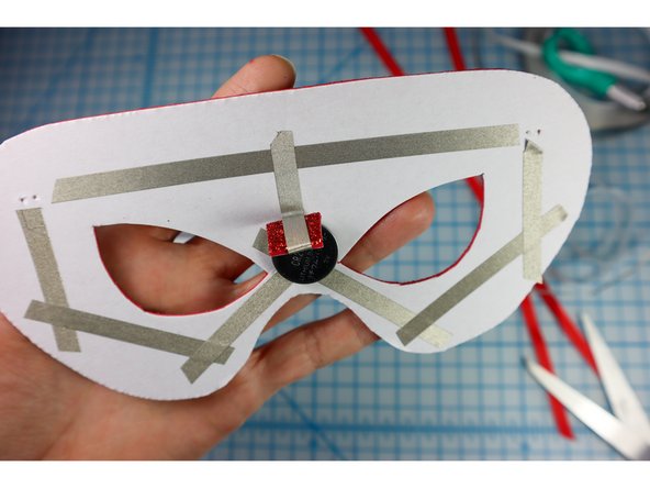 Stick the tape to the Negative side of the circuit as shown (between the eyes).