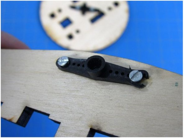 Use the two remaining small screws to attach a horn to the inside of one of the two triangle shaped pieces.