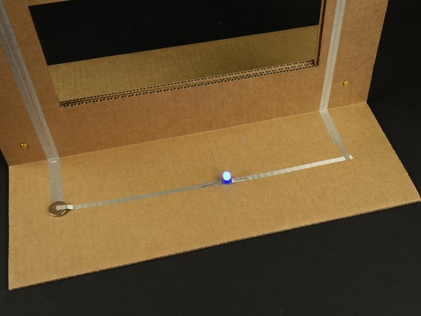 Note that the longer (positive) leg needs to connect on the left side, since the tape on the left connects to the positive side of the battery.