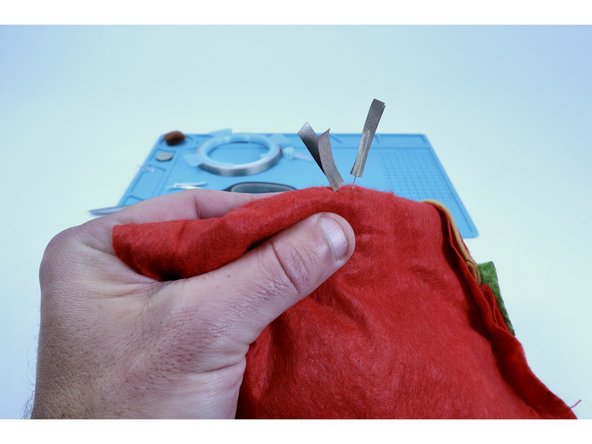 Turn your project inside out. Select two of your Maker Tape segments that you just cut. Peel and stick one of them to each of  LED legs as shown in the first photo. 