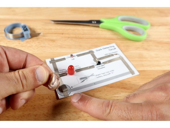 Stick the battery atop the tape loop with the Positive (+) Side facing UP.