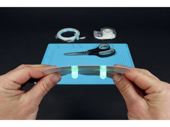 Peel and stick the longer piece of Maker Tape so that it contacts path &quot;B&quot; on one end and the top of the battery on the other end. This will turn your LEDs on! Simply peel back to turn them off.