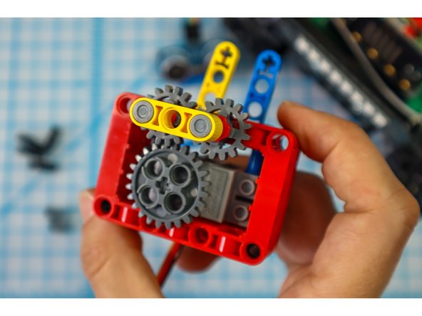 With the other gears aligned, add the main gear to the motorhead. The main gear should connect with one of the two smaller gears.