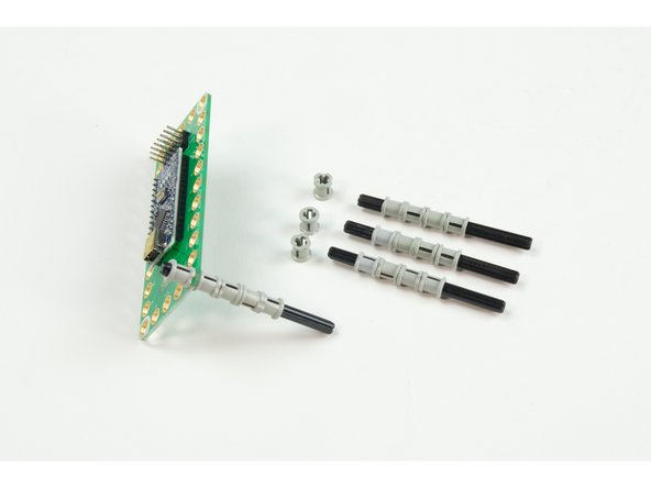 Place the Robotics Board onto the &quot;legs&quot; and add one LEGO Bushing to the top of each axle.