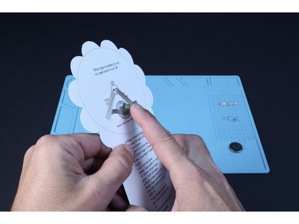 Stick the tape loop to the end of the tape path atop the battery graphic as shown in the second photo.