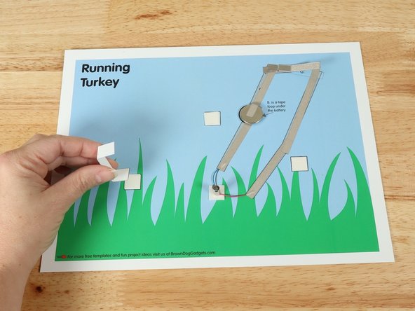 Add double-sided foam tape to the 3 white squares on the background scene.