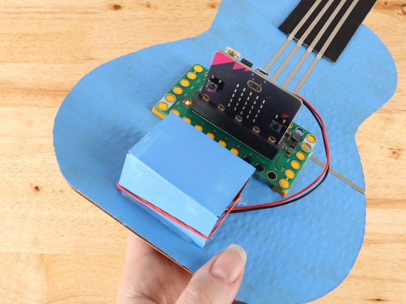 Slide the Battery Pack into the compartment and secure it in place with a rubber band.