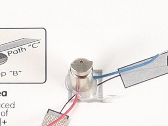 Stick the motor to the hot glue or double-sided tape making sure the back of the motor (with the wires) is stuck down to the glue/tape and the part that spins faces upwards so it can move freely.