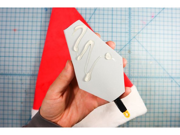 Glue the foam inside the peak of the Santa hat with the front of the hat matching the front of the foam piece.