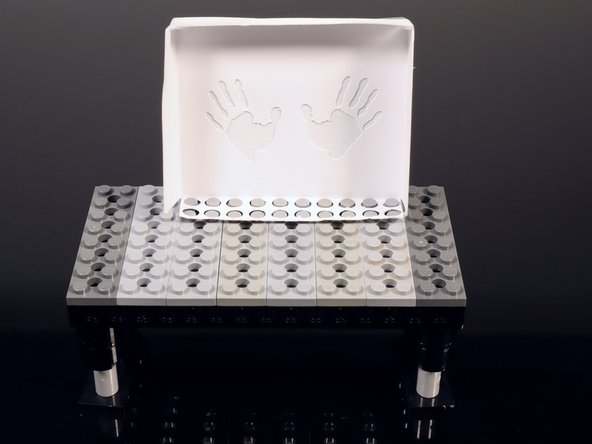 Place the completed shadowbox where shown on the instruction sheet. Remember to leave a single row of LEGO studs in front of the shadowbox.