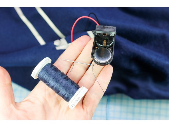 Sew the battery pack to the sweatshirt by stitching between the two holes inside the battery pack.