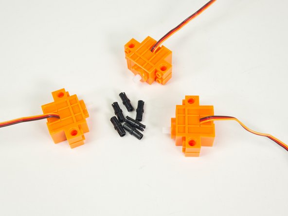 Gather all three servos and 6 black pins.