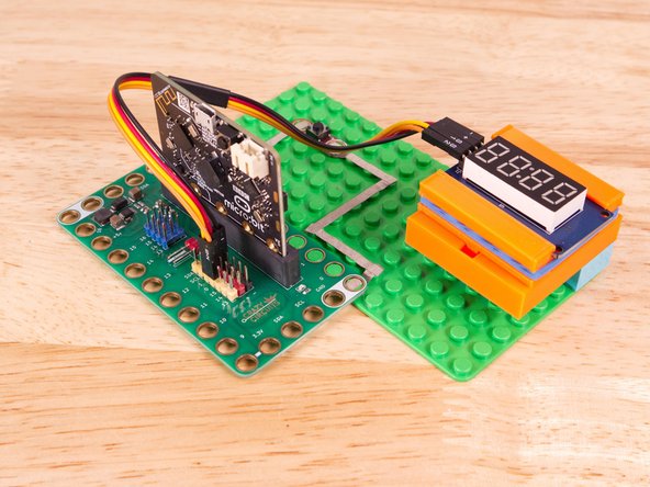 Now we'll connect the other end of the Ribbon Cable to the 7 Segment Display. The pin labels are on the back of the 7 Segment Display PCB. From top to bottom it's CLK, DIO, VCC, GND.