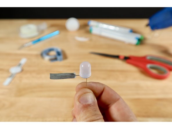 Notice that your LED has two legs of different length. The longer Positive (+) Leg will need to connect to the path on the template that comes from the TOP of the battery. The shorter Negative (-) Leg will need to connect to the path the comes from the BOTTOM of the battery.