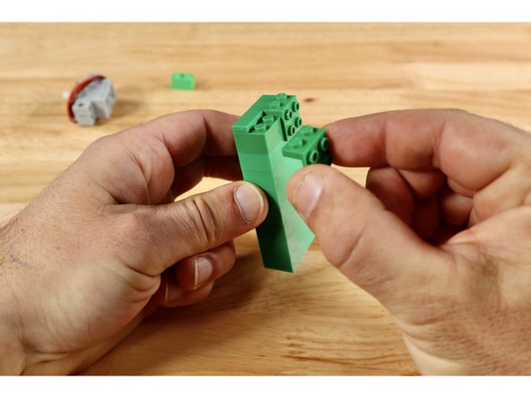 The grey brick-compatible 270 servo will be mounted atop and at a 90 degree angle from a simple tower to give it the height it needs to spin from in order to drive the gear rack upward enough for the desired end effect.