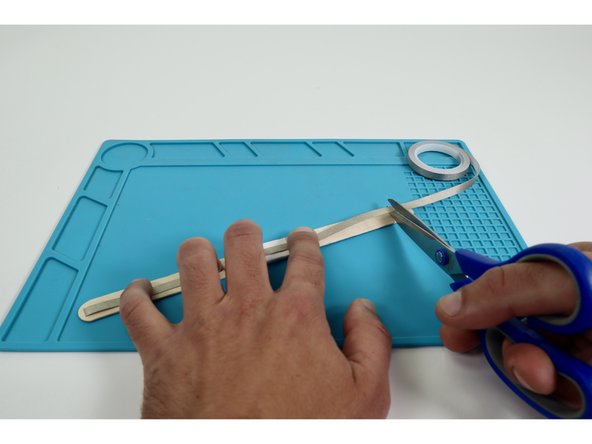 Measure and cut two separate Maker Tape pieces that are approximately the length of the wand handle you created.