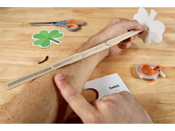 With the side of the wand handle with the gap in the tape path facing UPWARD in one hand, tilt the front topper piece so the stem is facing upward and the LED legs are aimed toward the end of the wand furthest from the gap.