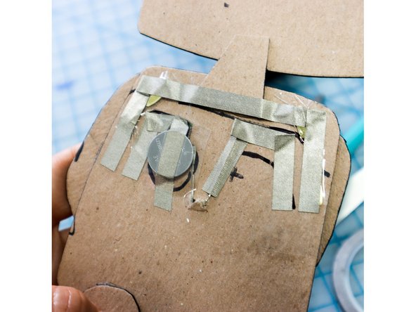 Place the battery on top of the Maker Tape with the negative side down.