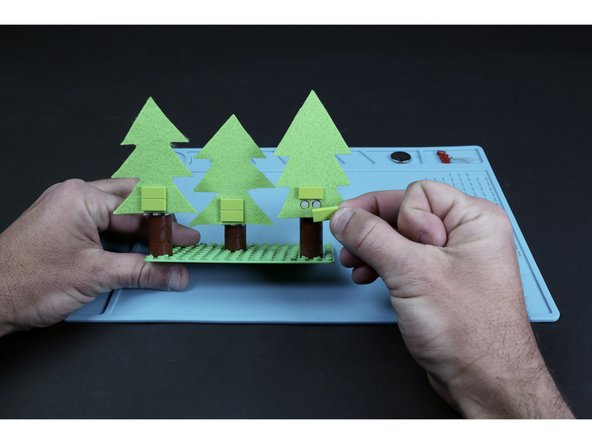 Attach each of the three trees to their respective trunks using the LEGO pieces indicated on the Physical Build Guide.