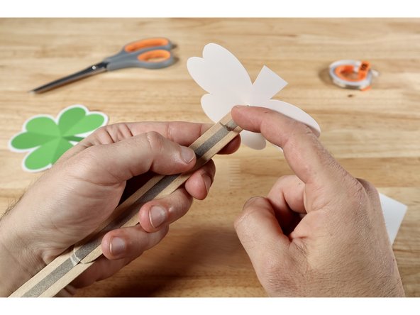 Position the wand handle between the two LED legs and use the piece of Maker Tape you have ready to tape/secure the leg that faces you on top of the handle path below it. 