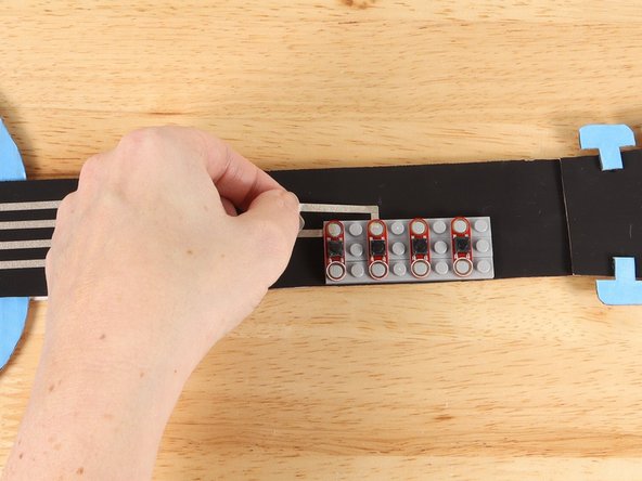 Place the button on top of the tape path to secure it in place.