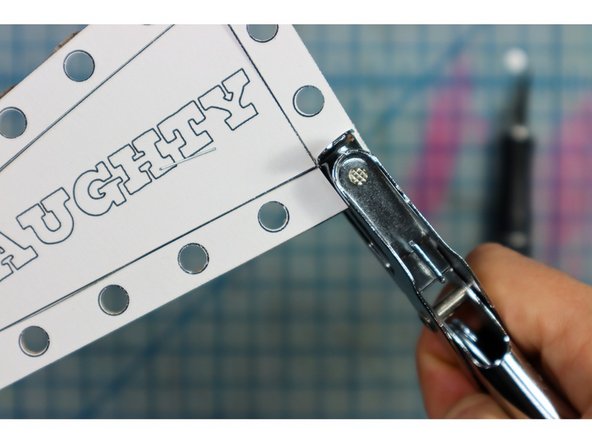 Staple the template to a piece of cardboard. We removed one side of the cardboard to make it easier to punch.