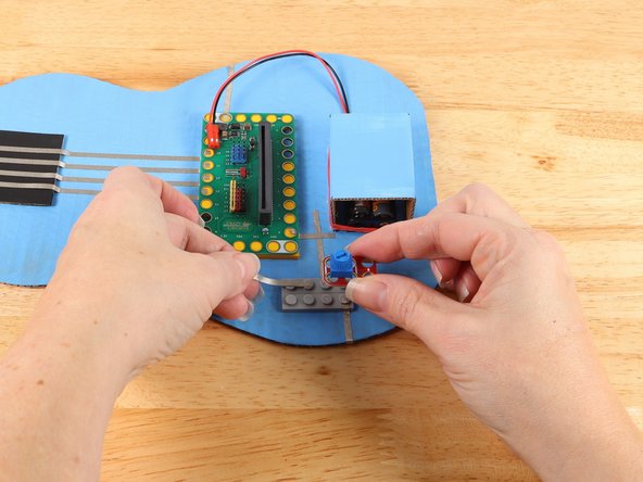 Use a piece of Maker Tape to start a path from the top hole of the potentiometer as pictured.