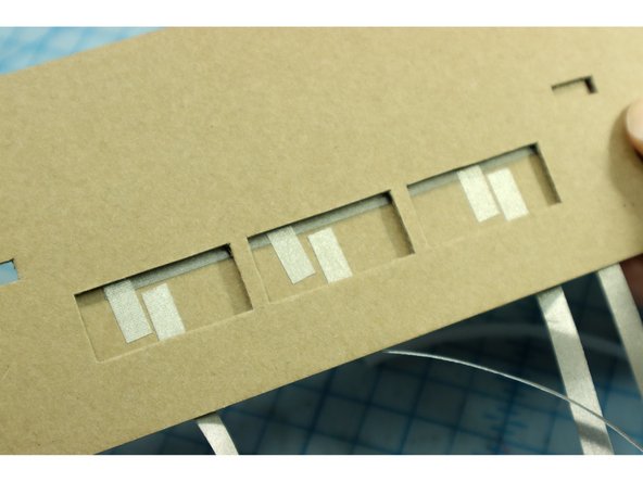 Place this piece below the top piece so that the parallel pieces in each switch are visible through the hole.