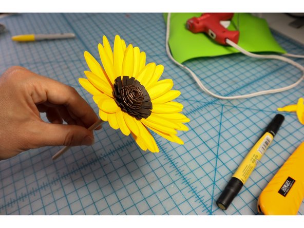 Glue the petals around the flower center. There should be enough to make about 3 rows.