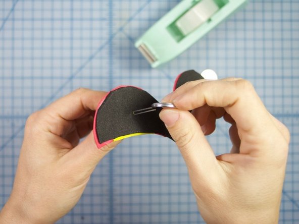 Insert the battery between the two legs. Make sure the long leg touches the &quot;+&quot; side of the battery and the short wire touches the &quot;-&quot;.