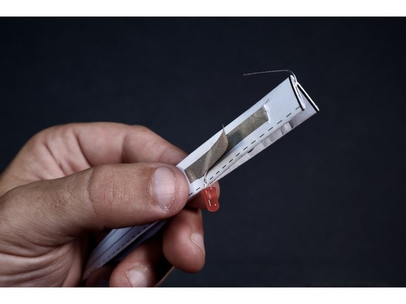 Use the 1&quot; long piece of Maker Tape to tape the long LED leg atop the nearby Maker Tape section (the only outside path that is taped down to the shape).