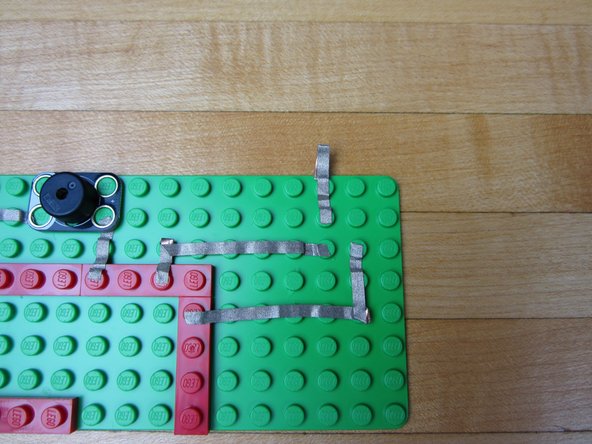 Use a piece of Maker Tape and and go from the second hole on the Screw Terminal off the side of your building surface.