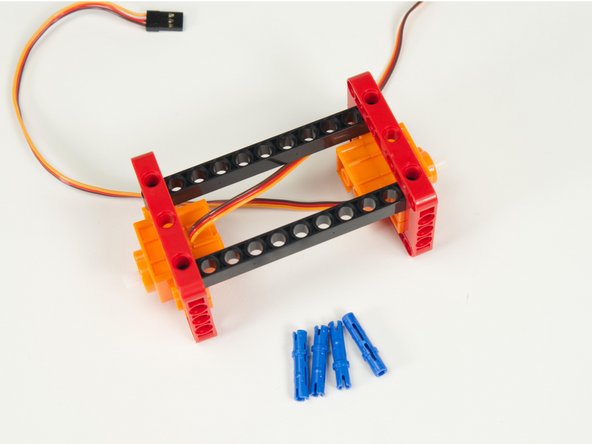 Slide the long beams in place inside the frame on top of the servos.
