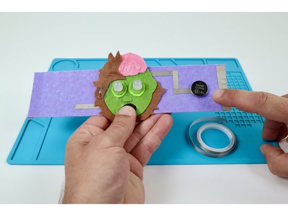 Stick your battery down atop that tape loop with the  Positive (+) Side UP.