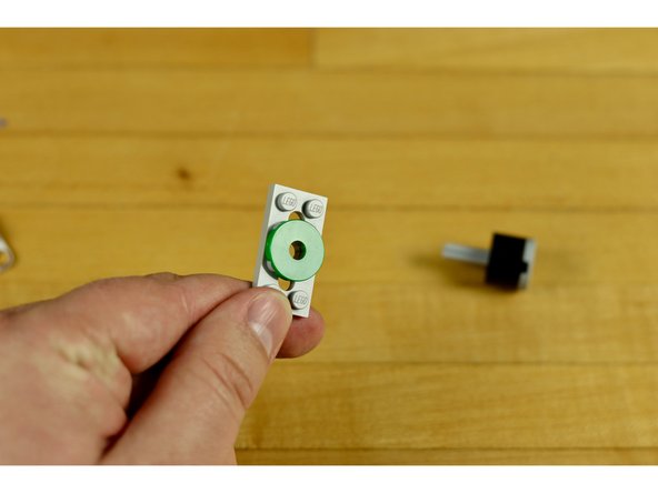 Use the 2x2 round tile with the hole in it and place it on top of the hole you wish to use on the plate.