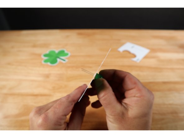 Thread the LED legs through the poked holes in the front portion of the topper so that the longer Positive (+) LED Leg goes through the upper hole and the shorter Negative (-) LED Leg goes through the lower one. ORIENTATION MATTERS! 