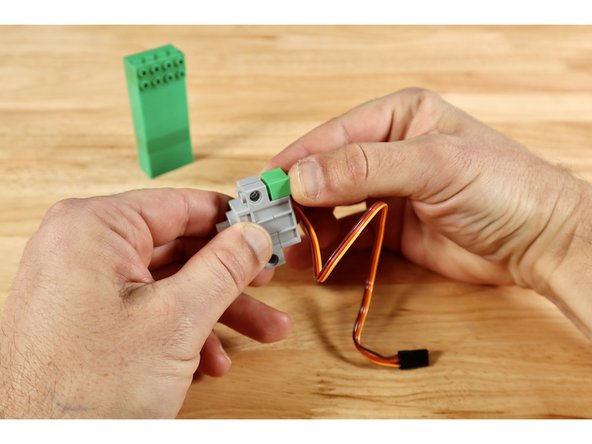 Stack 8 (2x4) bricks on top of one another. Then complete the top of the tower by connecting the two right angle brackets to one long side and the (1x4) plate in the space that remains. The tower should now have a (2x4) cluster of studs oriented outward when the tower is stood upward.