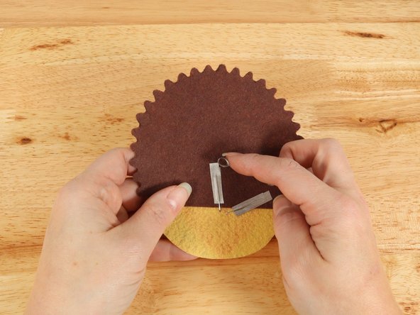 Make a loop of tape (sticky side out) using a short piece of Maker Tape, and stick it atop the end of the path coming from the short (Negative) LED leg.