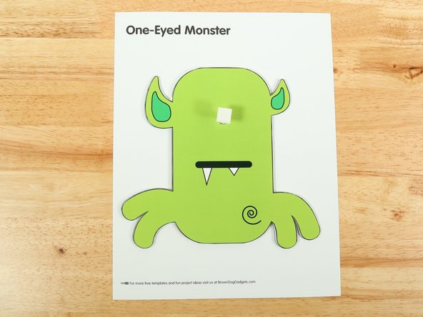 Add another square of double-sided tape onto the shaft of the motor, and then stick the eye to it.