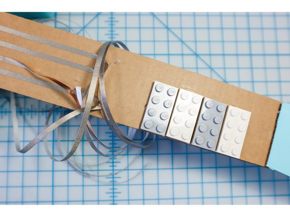 Glue the LEGO to the neck. You could use the neck template for reference, or place the buttons where your fingers will feel most comfortable.