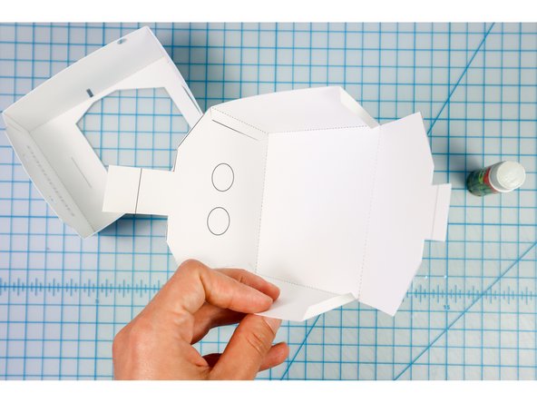 Fold the tabs and glue them to the interior of the head and body as shown.