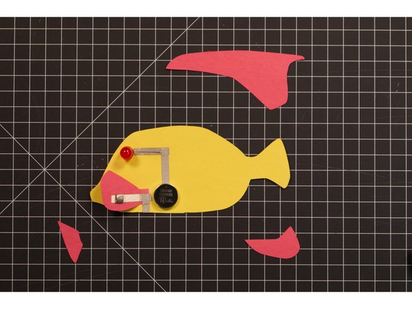 Once you’ve got the tape loops in place you can add the battery and then stick the fin down to the top. If you’ve done everything correct the eye should light up!